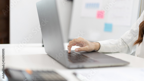 Businesswoman's hand presses on a laptop keyboard, World of technology and internet communication, Using computers to conduct financial transactions because the convenience and speed.