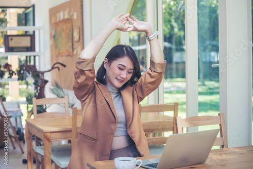 Foto Woman stretching arm raised sitting incorrect position at home office desk