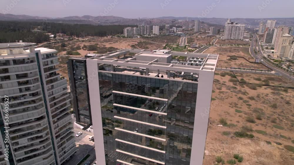 vista aérea desde dron rodeando un edificio con ventanas espejadas, se ...