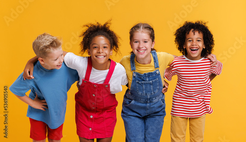 Group of cheerful happy multinational children on  yellow background