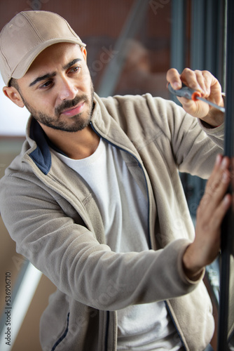 handsome young handyman installing bay window