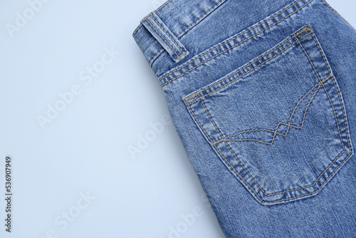 Folded jeans on a light blue background.