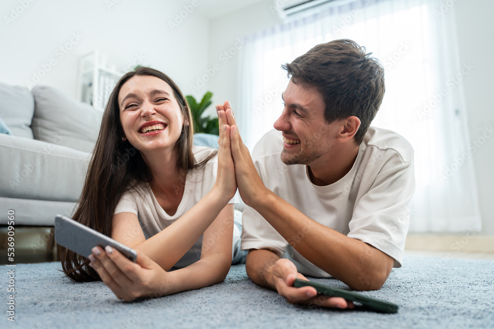 Caucasian attractive couple using smartphone play game in living room. Caucasian attractive couple using smartphone play game in living room.