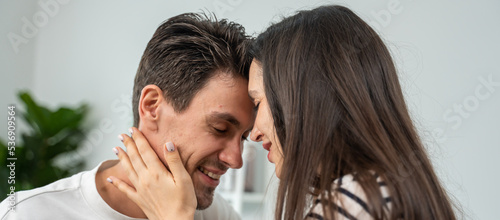 Caucasian young man and woman kissing each other in living room at home. 