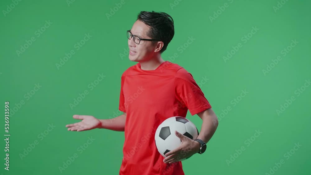 Side View Of Asian Man With A Ball Making Fun Of The Losers While Cheering Soccer On Green Screen Background
Side View Of Asian Man With A Ball Making Fun Of The Losers While Cheering Soccer On Green Screen Background
