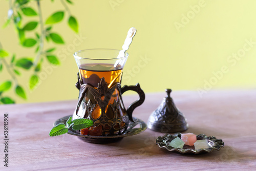 Cup of traditional turkish tea in glass with sweets.