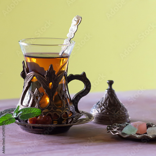 Close-up of traditional turkish tea in glass with sweets.