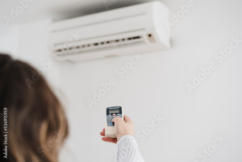 Businesswoman switching on air conditioning in the office