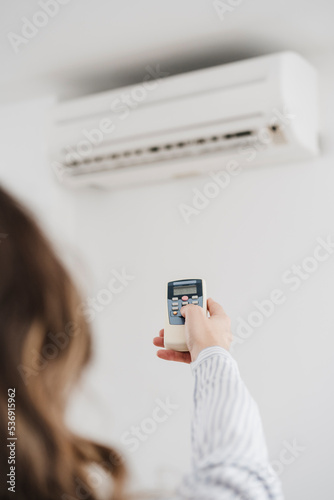 Businesswoman switching on air conditioning in the office photo