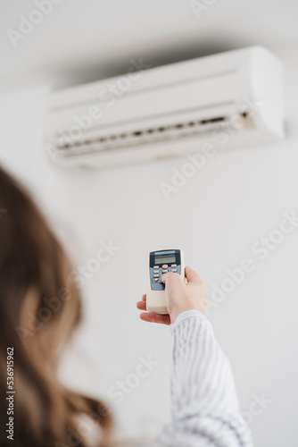 Businesswoman switching on air conditioning in the office