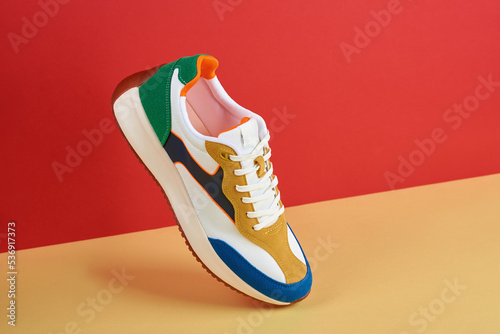 Fashionable sneakers on colorful background. Stylish sports casual shoes. Creative minimalistic layout with footwear