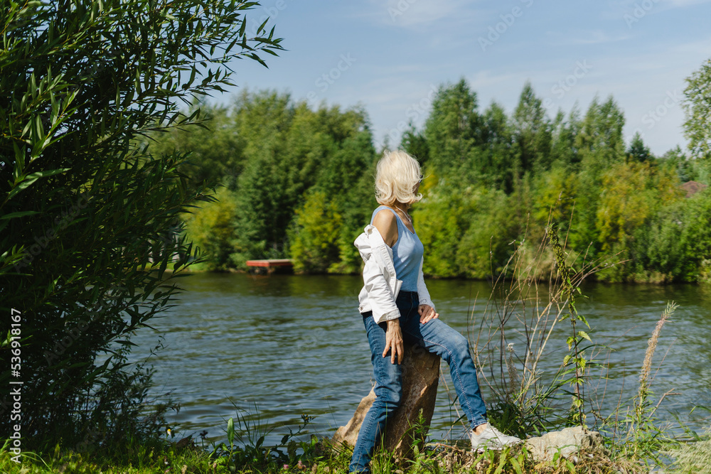 Senior woman looking at lake on sunny day Senior woman looking at lake on sunny day