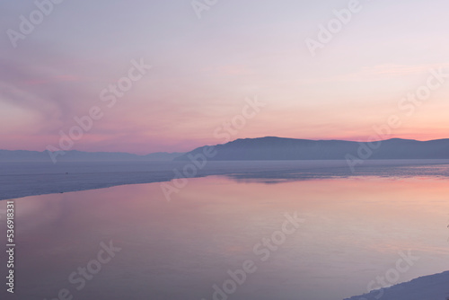 Beautiful sunset on frozen lake Baikal. Winter landscape. © anya babii