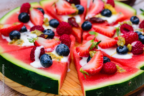Closeup of watermelon pizza with berries and yogurt
