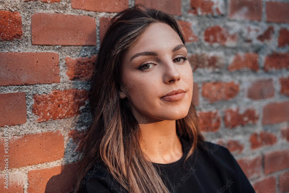 Young woman in front of brick wall Young woman in front of brick wall