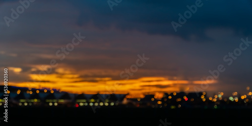 dark blurred background with sunset over the city