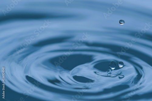 Water droplets are falling on the surface of the water.
