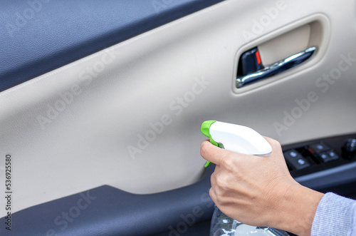 car wash and interior chemical cleaning concept.woman hand use microfiber cloth and spray to clean lateral door from inside retractable rear view mirror steering wheel.modern hybrid vehicle clean home