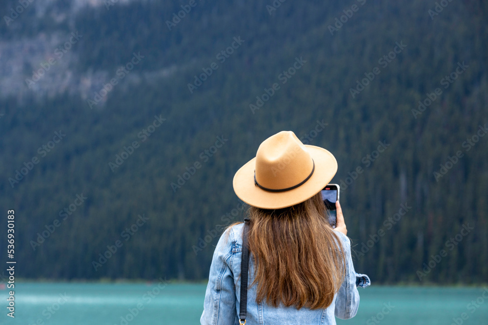 A lovely long hair lady takes pictures of Lake Louise