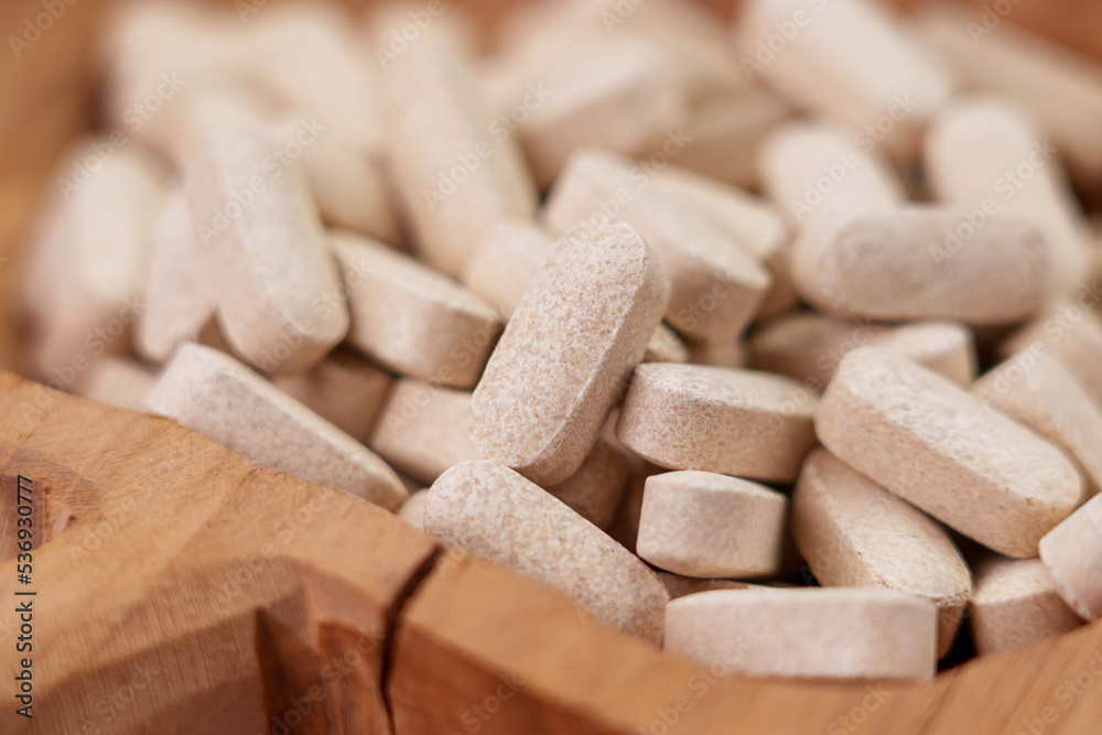 Vitamin nutritional supplement pills in cracked wooden rustic container Vitamin nutritional supplement pills in cracked wooden rustic container