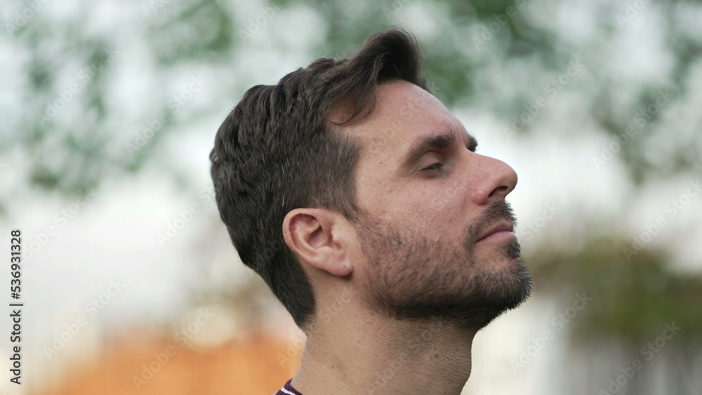 Meditative man standing outdoors opening eyes to sky feeling FREE. Contemplative person breathing outside Meditative man standing outdoors opening eyes to sky feeling FREE. Contemplative person breathing outside