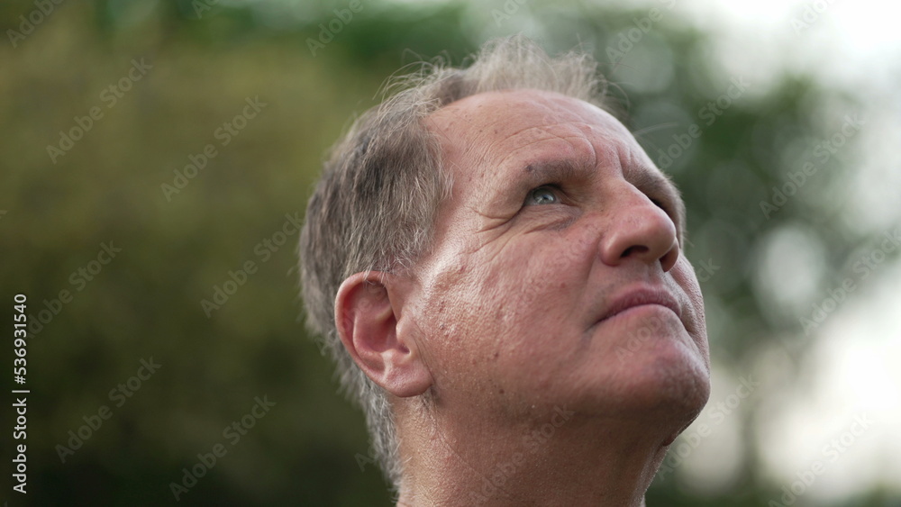Happy Mature man closeup face looking up at sky with HOPE and FAITH. Contemplative middle aged male older person smiling Happy Mature man closeup face looking up at sky with HOPE and FAITH. Contemplative middle aged male older person smiling