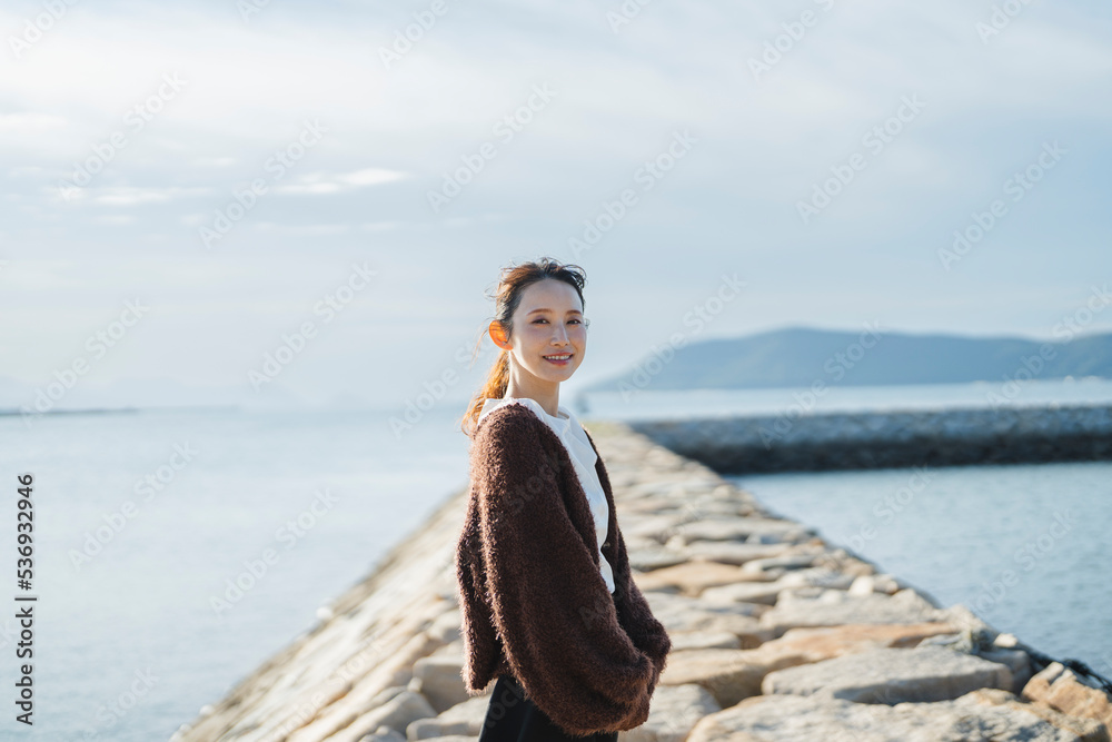 夕暮れの海にいる女性