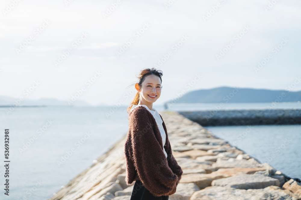 夕暮れの海にいる女性