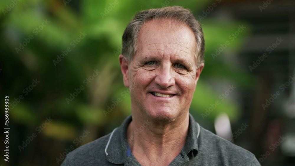 Portrait of a happy mature man standing outdoors smiling. Closeup face of a 50s male person Portrait of a happy mature man standing outdoors smiling. Closeup face of a 50s male person