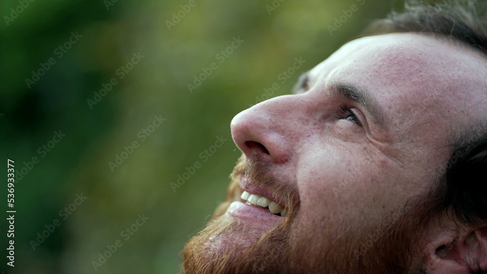 Fototapeta premium Grateful man closing eyes in meditation. Person opening eye to sky with HOPE and FAITH. Spiritual person smiling in contemplation
