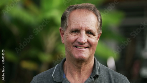 Portrait of a happy mature man standing outdoors smiling. Closeup face of a 50s male person