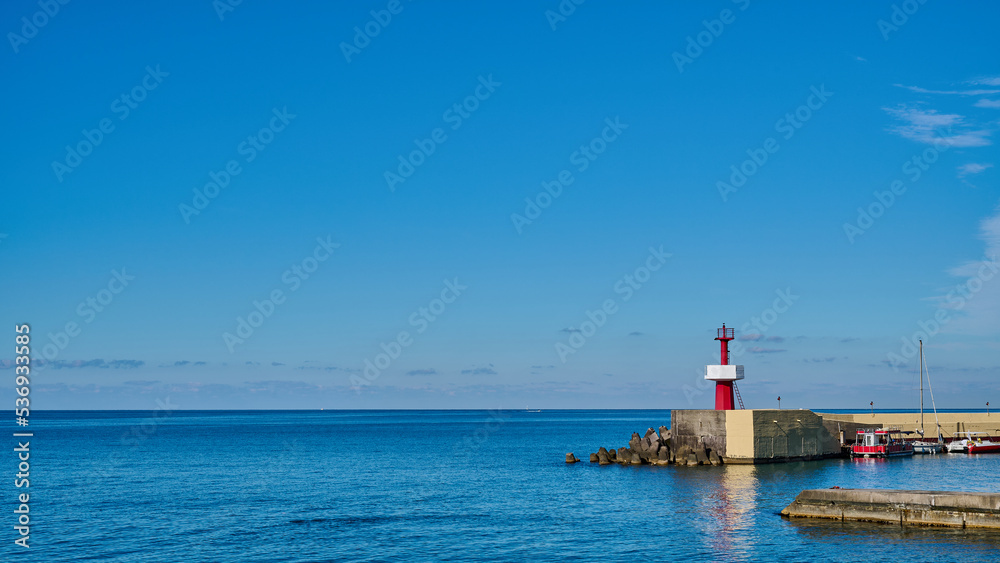 Panoramic view of little red lighthouse on the pier against the blue sky on sunny day, copy space