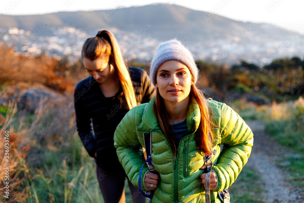 Female friends talking and hiking during sunrise