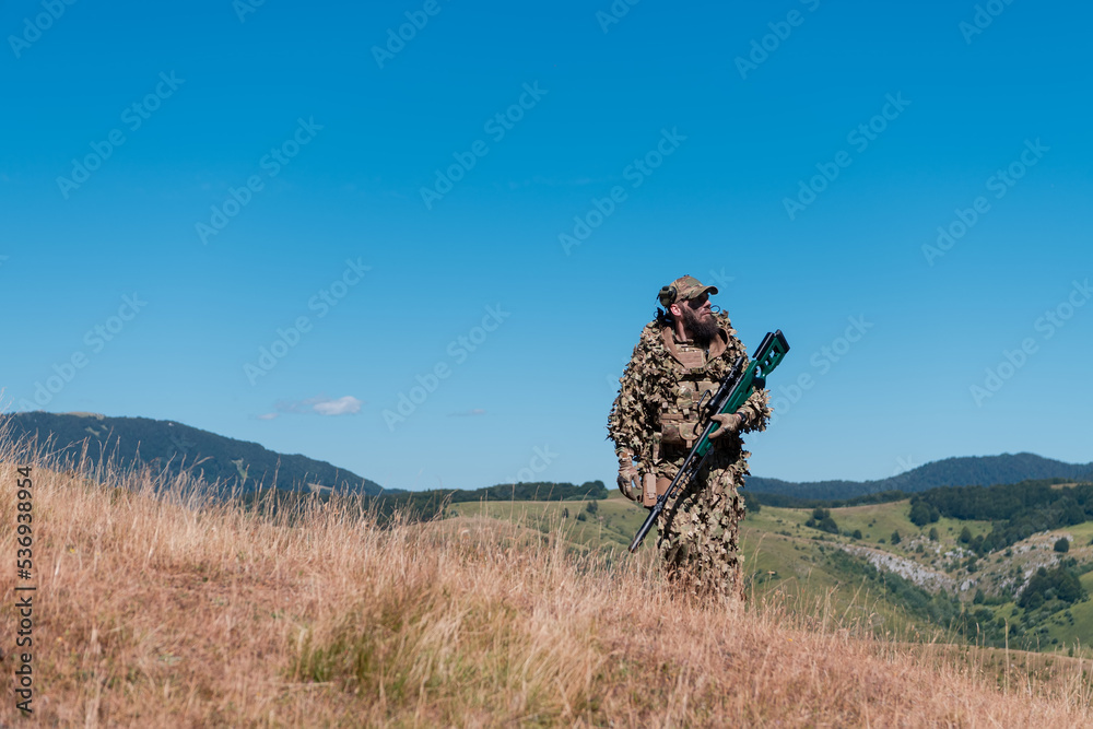 army soldier holding a sniper rifle with scope and walking in the forest. war, army, technology and people concept. army soldier holding a sniper rifle with scope and walking in the forest. war, army, technology and people concept.