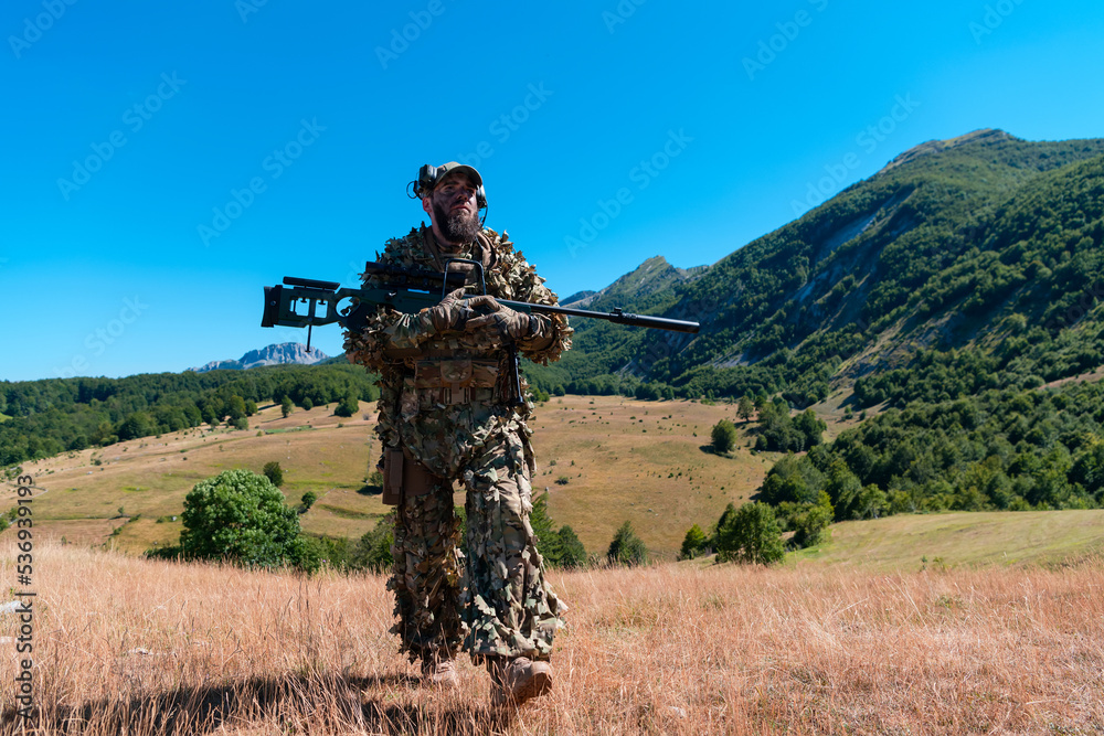 army soldier holding a sniper rifle with scope and walking in the forest. war, army, technology and people concept. army soldier holding a sniper rifle with scope and walking in the forest. war, army, technology and people concept.
