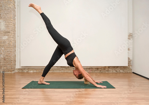 woman practicing yoga concept, standing in Three legged dog pose
