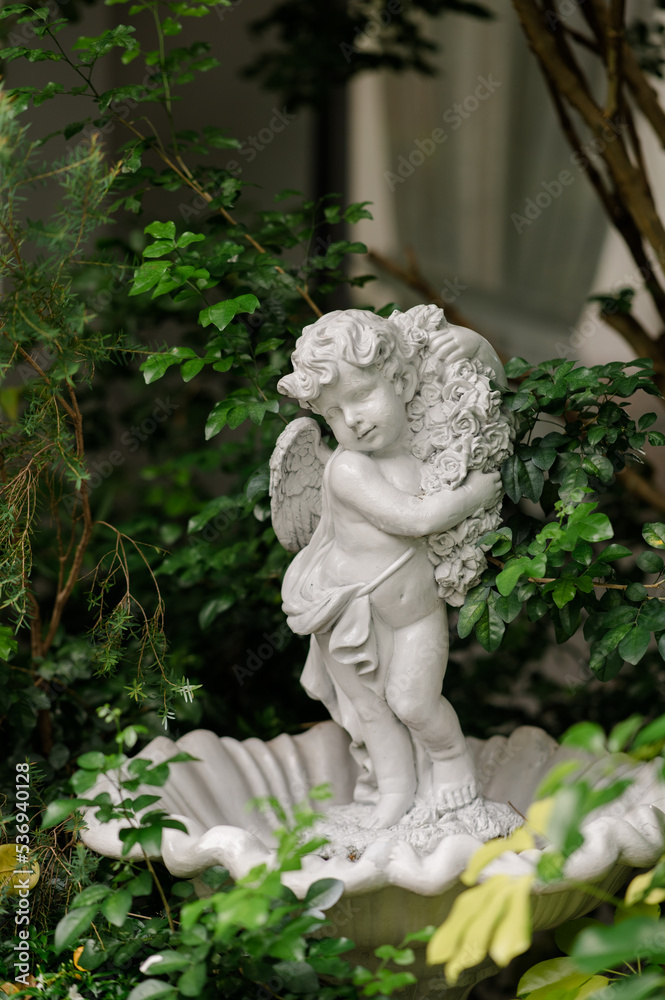 Cute baby corner antique stone doll statue, close-up of newly built home garden stone statue.