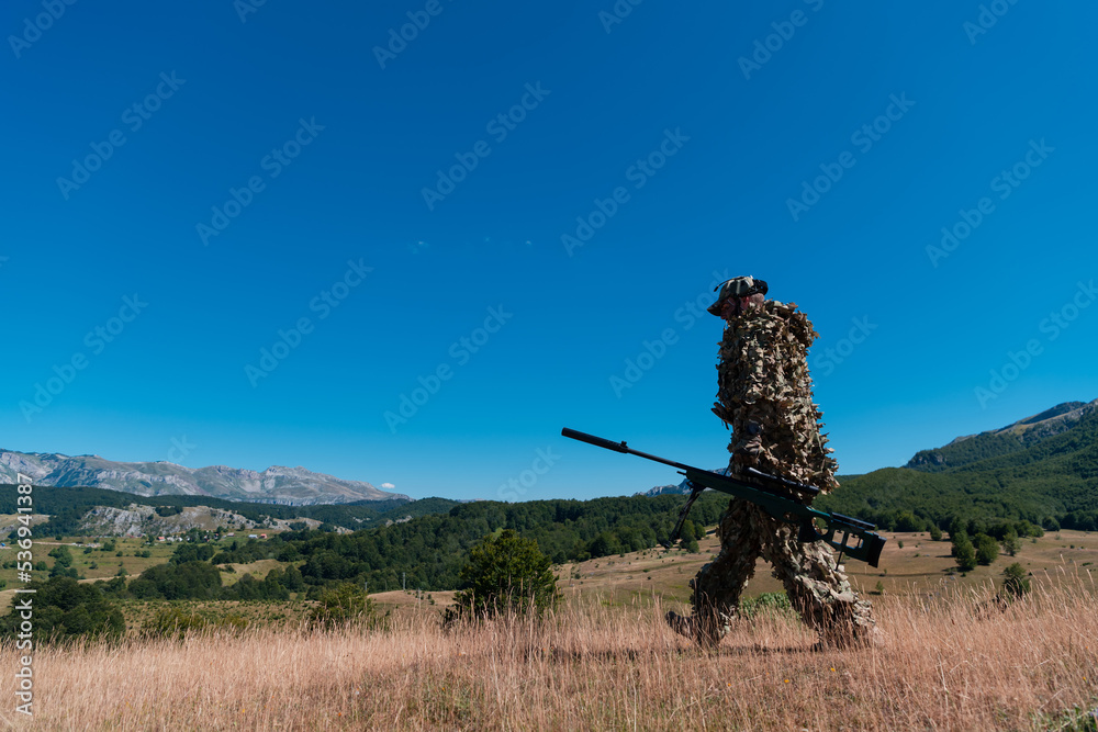 army soldier holding a sniper rifle with scope and walking in the forest. war, army, technology and people concept. army soldier holding a sniper rifle with scope and walking in the forest. war, army, technology and people concept.