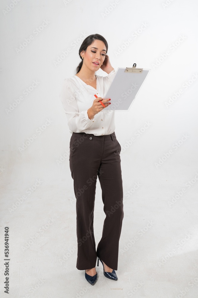Studio portrait photo of a young beautiful elegant Brazilian female businesswoman lady wearing smart casual business suit with folder board and pen posing with a series moments of emotion and gesture Studio portrait photo of a young beautiful elegant Brazilian female businesswoman lady wearing smart casual business suit with folder board and pen posing with a series moments of emotion and gesture