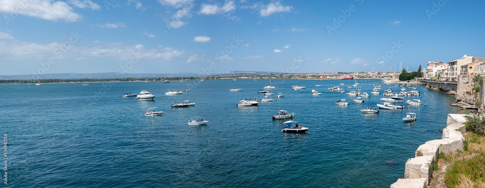 super wide angle view of the Gulf of Syracuse with many boats and blue water