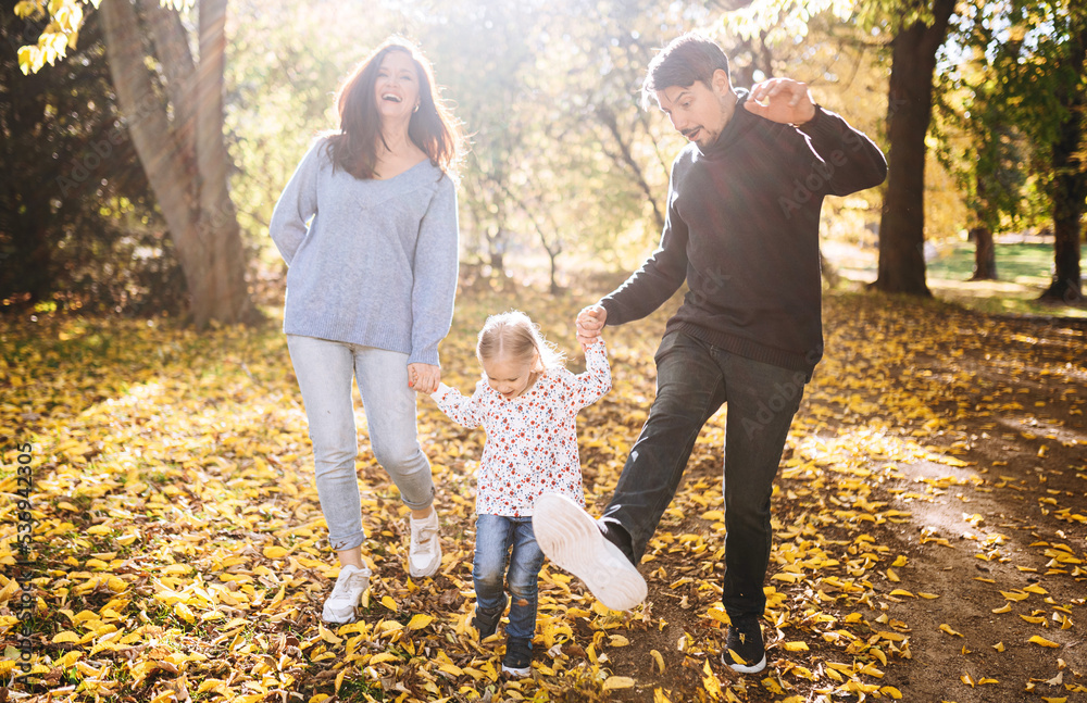 Fototapeta premium happy family with little daughter in autumn park outdoor recreation.