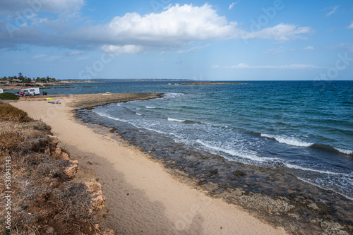 Fototapeta Naklejka Na Ścianę i Meble -  The beautiful Ognina beach in Syracuse with turquoise and green water and a small island in front of it