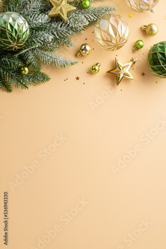 Christmas concept. Top view vertical photo of transparent gold and green baubles balls star ornaments pine branch in frost and confetti on isolated beige background with copyspace