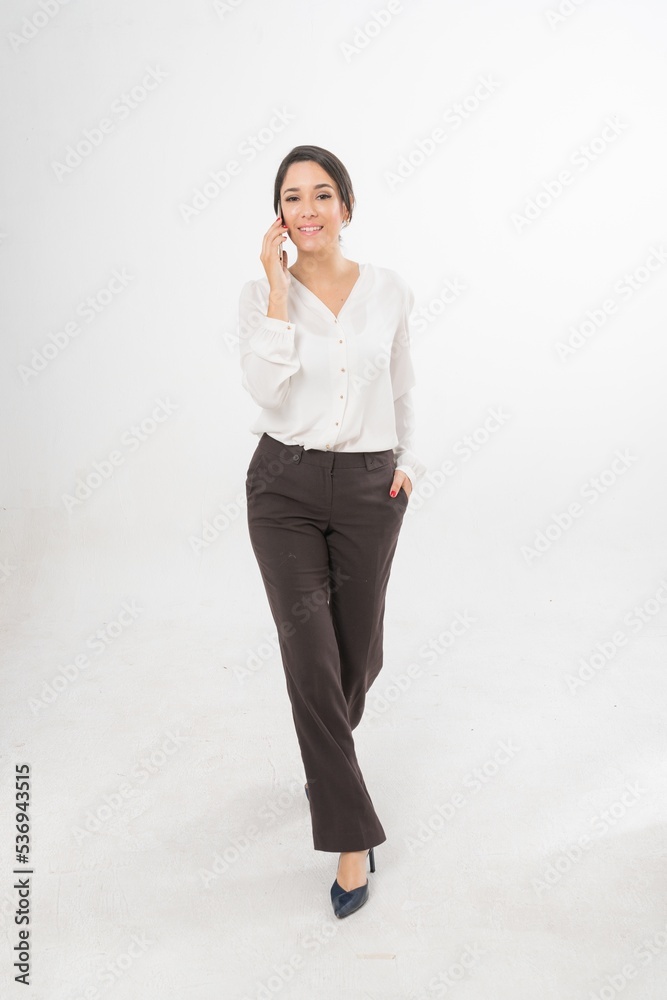 Studio portrait photo of a young beautiful elegant Brazilian female businesswoman lady wearing smart casual business attire posing with a series moments of emotion and gesture of using her smartphone Studio portrait photo of a young beautiful elegant Brazilian female businesswoman lady wearing smart casual business attire posing with a series moments of emotion and gesture of using her smartphone