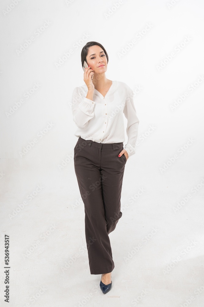 Studio portrait photo of a young beautiful elegant Brazilian female businesswoman lady wearing smart casual business attire posing with a series moments of emotion and gesture of using her smartphone Studio portrait photo of a young beautiful elegant Brazilian female businesswoman lady wearing smart casual business attire posing with a series moments of emotion and gesture of using her smartphone