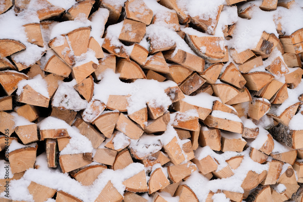 textured firewood background chopped wood for kindling and heating. woodpile with stacked firewood birch tree covered fresh icy frozen snow and snowflakes. cold weather and snowy winter time season textured firewood background chopped wood for kindling and heating. woodpile with stacked firewood birch tree covered fresh icy frozen snow and snowflakes. cold weather and snowy winter time season