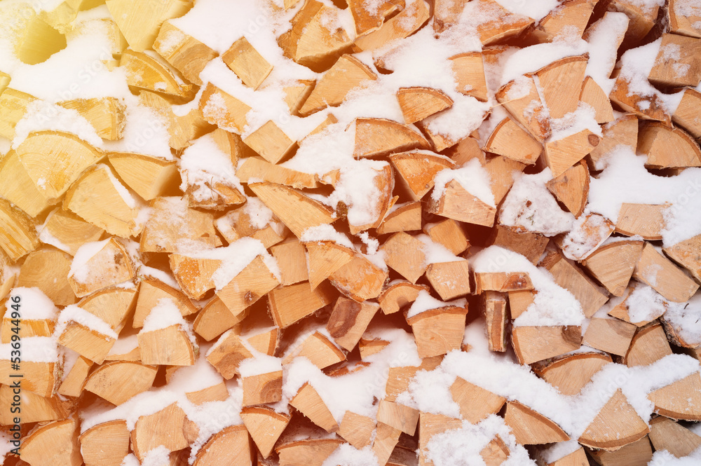 textured firewood background chopped wood for kindling. woodpile with stacked firewood birch tree covered fresh icy frozen snow and snowflakes. cold weather and snowy winter time season. flare textured firewood background chopped wood for kindling. woodpile with stacked firewood birch tree covered fresh icy frozen snow and snowflakes. cold weather and snowy winter time season. flare