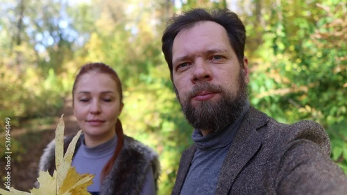 a man and a woman shoot a video for a blog in the autumn forest