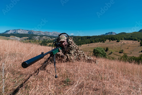 army soldier holding sniper rifle with scope and aiming in forest. war, army, technology and people concept