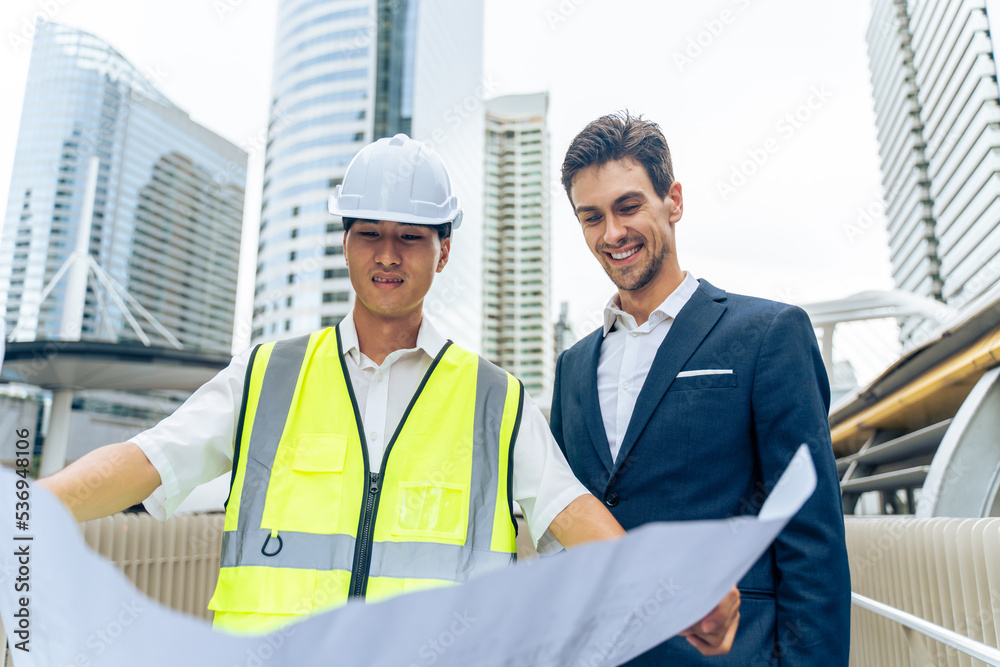 Caucasian businessman and Asian worker working in outdoors in city. Caucasian businessman and Asian worker working in outdoors in city.